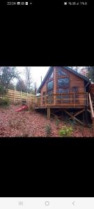 a large wooden cabin with a fence in front of it at Cabañas Alturas Doña Katalina in Chillán +8 photos