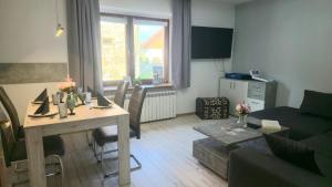 a living room with a table and a couch at Ferienwohnungen auf einem rustikalen 3 Seitenhof in Göda