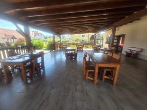 a patio with wooden tables and chairs in a restaurant at Apartmaji Picasso Design in Veržej