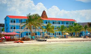 a blue building on the beach next to the ocean at El Faro Beach Front by ÓOL Hotels in Holbox Island