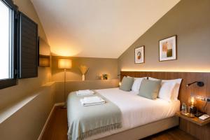 a bedroom with a large white bed with a window at Piu Bella in Fajã da Ovelha
