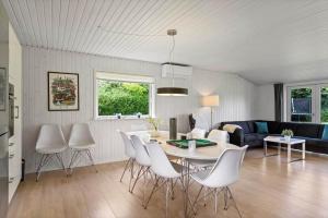 a living room with a table and white chairs at LL275-svendborg-Stenklovervej-2 in Svendborg