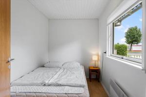 a white bedroom with a bed and a window at LL275-svendborg-Stenklovervej-2 in Svendborg
