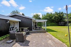 a backyard with a patio with chairs and a table at LL275-svendborg-Stenklovervej-2 in Svendborg