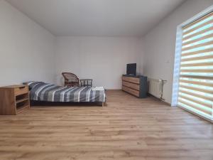 a bedroom with a bed and a dresser and a television at Domek na wzgórzu in Sosnowice