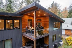 a house with a deck with people sitting on it at Aspire at Mount Baker in Glacier