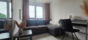 a living room with a blue couch and a desk at Apartament Słowackiego Sopot in Sopot