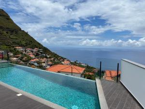 a swimming pool with a view of the ocean at Villa Sea View in Arco da Calheta