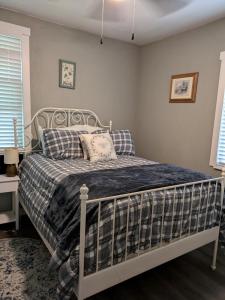 a bedroom with a bed with a blue plaid blanket at Country side house with with cozy 3 bedrooms and 2 bath in Minneola