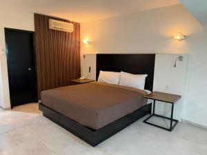 a bedroom with a large bed and a table at Hotel Solé Plaza Guadalajara in Guadalajara +8 photos
