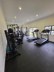 a gym with a row of treadmills and machines at 77 on Par in Boksburg