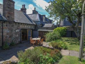 a patio with a table and chairs in a yard at St Kilda in Ballater