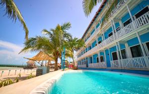 a building with a swimming pool next to the beach at El Faro Beach Front by ÓOL Hotels in Holbox Island +65 photos