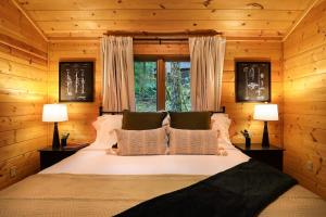 ein Schlafzimmer mit einem großen weißen Bett und zwei Lampen in der Unterkunft Forest Embrace in Glacier
