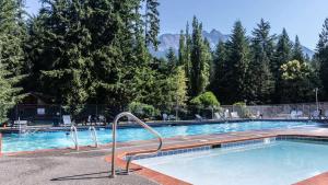 Ein Swimmingpool in einem Ferienort mit Bergen im Hintergrund in der Unterkunft Forest Embrace in Glacier