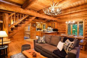 ein Wohnzimmer mit einer Couch in einer Blockhütte in der Unterkunft Forest Embrace in Glacier + 39 Fotos