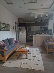 a living room with a couch and a coffee table at maison entre forêt et mer in Raʼs al Jabal