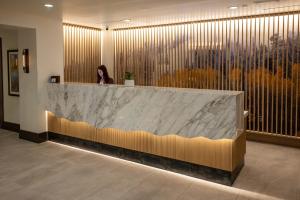 a woman sitting at a reception desk in a lobby at The Chateaux Deer Valley in Park City