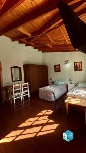 a bedroom with two beds and a table in a room at Isla Bella in Ushuaia