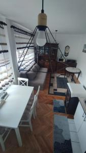 a living room with a white table and chairs at Apartman Čeliković centar Šamca, parking, balkon, WiFi in Bosanski Šamac
