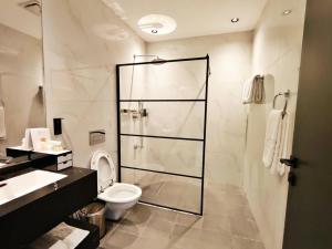 a bathroom with a shower and a toilet and a sink at 皇冠半岛酒店 - TAJ Boutique Hotel in Baghdād +16 photos