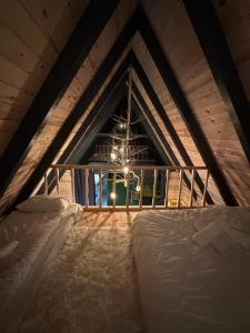 a attic bedroom with two beds and a window at Peak ayder bungalow in Ayder Yaylasi