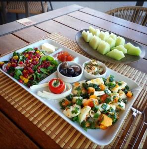 a tray of food with vegetables and fruits on a table at Bohem Pansiyon in Kuşadası
