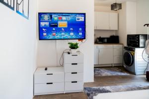 a kitchen with a tv hanging on a wall at 33A4. Rooftop Studio w Terrace Green Views in Sheikh Zayed