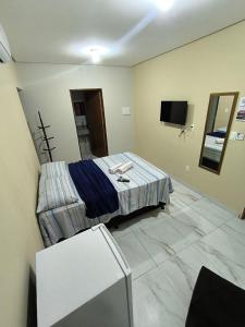 ein Hotelzimmer mit Bett und Fernseher in der Unterkunft Pousada Paulo's in Caruaru