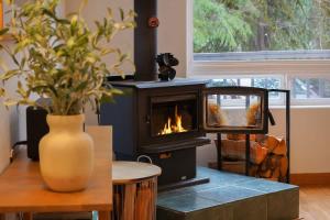 a fireplace in a room with a table and a vase at Colfax Cabin in Glacier