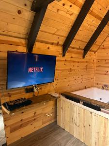 a television in a wooden room with a tub at Peak ayder bungalow in Ayder Yaylasi