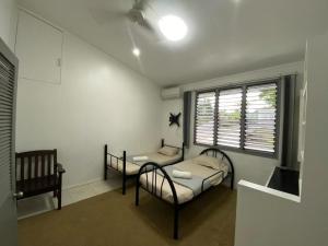 a small room with two beds and a window at Muaicolo House in Suva