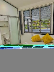 a room with a bed with yellow pillows on it at Muaicolo House in Suva +11 photos