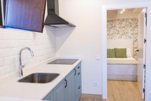 a kitchen with a sink and a bed in a room at Apartamentos San Roque in Arenas de Cabrales +73 photos
