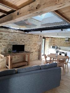 a living room with a couch and a table at Instant Lot Maison pierre insolite Piscine Nature in Strenquels