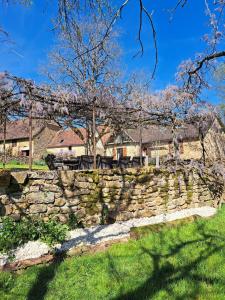 a stone wall in front of a house at Instant Lot Maison pierre insolite Piscine Nature in Strenquels