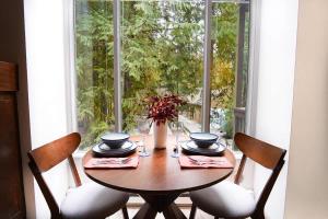 a wooden table with four chairs and a window at Twin Lakes Retreat in Glacier