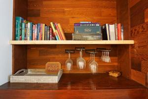 a book shelf with wine glasses and books on it at Twin Lakes Retreat in Glacier
