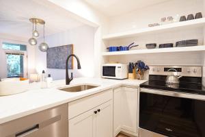 a white kitchen with a sink and a microwave at Twin Lakes Retreat in Glacier