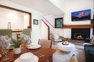 a living room with a table and a fireplace at Cascade Peaks in Glacier +28 photos