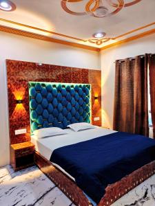 a bedroom with a large bed with a blue headboard at The Sapphire Retreat in Srinagar +3 photos