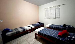 a room with two beds and a window at Casa Miríades in Hortolândia