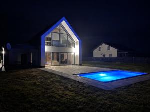 a house lit up at night with a swimming pool at Dom z Widokiem in Łączonek