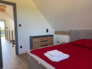 a bedroom with a red bed with a red blanket at Dom z Widokiem in Łączonek +30 photos