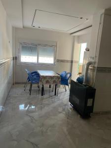 a room with a table and chairs and a tv at Front de mer salamndre in Mostaganem +6 photos