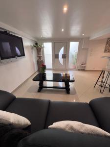 a living room with a couch and a table at Appartement Carreira in LʼIsle-Adam