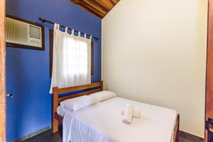 um quarto com duas camas e uma parede azul em Viamar Pousada em Caraguatatuba