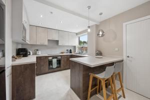 a kitchen with a counter and some chairs in it at Spacious Modern home in the heart of Whitefield - Private Driveway Parking in Whitefield