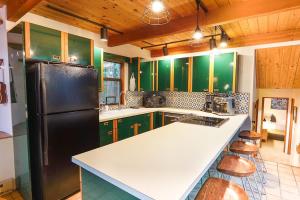 a kitchen with green cabinets and a black refrigerator at Skywood in Deming