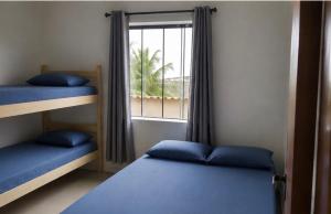 a room with two bunk beds and a window at Cibratel Hostel - Pé na Areia in Itanhaém